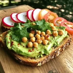 - 1 perfectly ripe avocado - 1 cup canned chickpeas, thoroughly rinsed and drained - 4 slices of hearty whole-grain bread - 1 tablespoon creamy tahini - 1 tablespoon fresh lemon juice - 1 garlic clove, finely minced - Salt and freshly cracked pepper to taste - 1 teaspoon olive oil - Fresh cilantro or parsley, finely chopped, for garnish This list includes all the key items for a delicious chickpea avocado toast. The ripe avocado brings creaminess, while canned chickpeas add a nutty flavor and protein. Whole-grain bread serves as a hearty base, making this meal filling and healthy. The tahini, lemon juice, and garlic enhance the taste, giving it a zesty kick. For seasoning, salt and pepper balance the flavors, and a drizzle of olive oil adds richness. Don't forget the fresh herbs for color and freshness. This chickpea avocado toast is not just simple but also packed with nutrition. For the complete recipe, check out the Full Recipe section. 1. Start by taking your ripe avocado. Cut it in half and remove the pit. 2. Use a fork to mash the avocado in a medium bowl. Aim for a creamy texture but keep some small chunks. 3. In another bowl, mix the rinsed chickpeas with tahini, lemon juice, minced garlic, salt, and pepper. 4. Use a fork to lightly mash the chickpeas. You want a mix that is chunky and smooth. 5. Gently fold the mashed avocado into the chickpea mix. Make sure they blend well. Taste and adjust with salt and pepper if you want. 1. Heat a non-stick skillet over medium heat. Add the olive oil to the skillet. 2. Place the slices of whole-grain bread in the skillet. Toast each side until they are golden brown, about 2-3 minutes per side. 3. Once toasted, take the bread out of the skillet. 1. Spread the chickpea-avocado mixture generously on each slice of bread. Let it mound on top for a nice look. 2. If you like spice, sprinkle red pepper flakes over your toast. 3. Garnish with finely chopped cilantro or parsley for extra color and flavor. For the complete recipe, visit the [Full Recipe]. To make the best avocado mash, select a ripe avocado. Look for one that gives slightly when you press it. This means it is ready to use. Overripe avocados can taste bitter, so choose wisely. For a perfect texture, mash the avocado with a fork. Leave some small chunks for a nice bite. The mix of smooth and chunky adds character to your toast. For golden toast, there are a few great methods. You can use a skillet or a toaster. If you want a crispy side, the skillet is best. Heat some olive oil and toast the bread until golden brown. This takes about 2-3 minutes per side. If using a toaster, set it to a medium setting. Check the bread to avoid burning. The goal is a crispy outside with a soft inside. Presentation matters! Serve your toasts on a wooden board or a bright plate. This makes the meal look more inviting. Add fresh tomato or radish slices on the side. They add color and freshness to the plate. For a fun touch, you can also sprinkle extra herbs on top of the toast. Enjoy your Chickpea Avocado Toast Delight with these simple yet effective serving ideas. {{image_4}} To make your chickpea avocado toast even better, add spices and herbs. - Spices: Try cumin for a warm taste. Smoked paprika adds a smoky note. You can also add curry powder for an exotic twist. Each spice brings its own charm. - Herbs: Fresh herbs can change the whole dish. Basil gives a sweet touch. Mint adds freshness. Chives offer a mild onion flavor. Experiment with what you love best. You can switch up the toppings to make your toast unique. - Vegetables: Sliced radishes add crunch. Cherry tomatoes give a sweet burst. Thinly sliced cucumber keeps it refreshing. You can also add arugula for a peppery kick. - Cheese: If you enjoy cheese, sprinkle feta for a tangy touch. Goat cheese also works well, adding creaminess. For a vegan option, try cashew cheese. It melts beautifully and tastes great. Choosing the right bread can change your toast game. - Gluten-free options: If you need gluten-free bread, look for brands made from almond flour or chickpeas. They hold up well and taste good too. - Different types of bread: Sourdough offers a tangy flavor. Rye bread has a hearty taste. Whole wheat adds fiber. Experiment with your favorites to find the best fit for your chickpea avocado toast. For the complete recipe, refer to the Full Recipe section. To keep your chickpea avocado toast fresh, store it in an airtight container. You can place it in the fridge for up to two days. Avoid stacking the toasts to prevent sogginess. Keep the chickpea-avocado mixture separate if possible. This helps maintain the texture of the bread. When reheating, use a skillet instead of a microwave. This method helps keep the toast crispy. Heat the skillet over medium heat and place the toast in it. Warm for about one minute on each side. Check for warmth, but do not overheat, as this can make the toast tough. You can freeze the chickpea-avocado mixture, but not the toast. Place the mixture in a freezer-safe container. It can last for up to three months. When ready to use, thaw it in the fridge overnight. Mix it well before spreading on fresh toast. This method keeps the flavors intact. For the full recipe, check the earlier sections. Enjoy your meal! What are the health benefits of chickpeas and avocados? Chickpeas and avocados pack a punch of nutrition. Chickpeas are high in protein and fiber. They help keep you full and support digestion. Avocados are rich in healthy fats and vitamins. They boost heart health and provide energy. Together, they make a great team for a healthy meal. How do I know if my avocado is ripe? To check if an avocado is ripe, gently squeeze it. It should feel slightly soft but not mushy. Look for a darker skin color, but remember, not all avocados change color the same way. If the stem comes off easily and is green underneath, your avocado is ripe and ready to enjoy. Can I make this recipe vegan? Yes, this recipe is already vegan! It uses chickpeas and avocados, which are plant-based. The tahini adds creaminess without any animal products. You can enjoy this meal guilt-free. How to adjust the recipe for larger servings? To serve more people, simply double or triple the ingredients. For example, use two or three avocados and two cups of chickpeas. Just make sure you have enough bread for everyone. This dish is easy to scale up for gatherings or meal prep. What can I use instead of tahini? If you don't have tahini, you can use almond butter or sunflower seed butter. Both will add creaminess and flavor. You could also skip it entirely if you prefer a lighter taste. Alternatives for chickpeas or gluten-free bread options? If you cannot use chickpeas, try white beans or black beans. They offer similar texture and flavor. For gluten-free bread, look for gluten-free whole-grain options at your store. You can also use lettuce wraps for a low-carb choice. For the full recipe, check out the Chickpea Avocado Toast Delight! This blog post covered how to make a tasty chickpea-avocado toast. We explored key ingredients, like ripe avocados and chickpeas, plus seasonings that add flavor. The step-by-step instructions make it easy to prepare, toast, and serve. We also shared tips for perfecting your mash and variations to try. Remember, you can store leftovers and even freeze the mixture for later. Enjoy experimenting and savoring this healthy dish! Your kitchen adventure can lead to delicious meals every time.