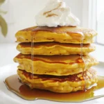 To make delicious pumpkin pancakes, gather these simple ingredients: - 1 cup all-purpose flour - 1 cup canned pumpkin puree - 2 tablespoons packed brown sugar - 1 teaspoon baking powder - 1/2 teaspoon baking soda - 1 teaspoon ground cinnamon - 1/2 teaspoon ground ginger - 1/4 teaspoon ground nutmeg - 1/4 teaspoon fine sea salt - 1 large egg - 1 cup buttermilk (room temperature) - 2 tablespoons unsalted butter, melted - Maple syrup, for serving - Whipped cream (optional, for garnish) Each ingredient plays a key role in making these pancakes light and flavorful. The pumpkin puree adds moisture and a rich taste. The spices create warmth and depth. The buttermilk gives a nice tang and helps the pancakes rise. When combined, these ingredients create a cozy flavor that warms your soul. For the sweetest touch, don’t forget the maple syrup! It brings out the pumpkin flavor perfectly. You can even add whipped cream on top for extra joy. Enjoy gathering these items and let’s make something special! First, gather all your dry items. In a medium bowl, add: - 1 cup all-purpose flour - 2 tablespoons packed brown sugar - 1 teaspoon baking powder - 1/2 teaspoon baking soda - 1 teaspoon ground cinnamon - 1/2 teaspoon ground ginger - 1/4 teaspoon ground nutmeg - 1/4 teaspoon fine sea salt Whisk these together well. This step makes sure every bite is tasty. Next, grab a large bowl for the wet mix. Combine: - 1 cup canned pumpkin puree - 1 large egg - 1 cup buttermilk (room temperature) - 2 tablespoons unsalted butter, melted Whisk until smooth. This mix adds moisture and flavor to your pancakes. Now, it's time to mix the wet and dry ingredients. Slowly pour the wet mix into the dry bowl. Stir gently with a spatula. You want it just mixed, so some lumps stay. Lumps make the pancakes fluffy. Preheat your non-stick skillet over medium heat. Lightly grease it with cooking spray or butter. Pour 1/4 cup of batter onto the skillet for each pancake. Cook until bubbles form, about 2-3 minutes. Carefully flip each pancake. Cook for another 1-2 minutes until golden brown. Repeat this with the rest of the batter, adjusting heat if needed. Serve warm, drizzled with maple syrup. Enjoy the sweet fall flavor! To make fluffy pancakes, keep it simple. Avoid overmixing the batter. When you combine wet and dry ingredients, stir gently. You want small lumps to remain in the batter. These lumps help create air pockets that make your pancakes light and fluffy. Getting the heat right is key. Start with medium heat on your skillet. Too hot, and your pancakes will burn. Too low, and they will cook unevenly. Look for a golden brown color when you're ready to flip. Adjust the heat as needed to keep that perfect balance. When serving, stack the pancakes high on a plate. Drizzle warm maple syrup over them generously. For a special touch, add a dollop of whipped cream on top. You can also sprinkle a little cinnamon or nutmeg for extra flavor. These small details make your dish look as good as it tastes. {{image_4}} You can switch the all-purpose flour with whole wheat flour for a heartier pancake. Whole wheat gives a nutty taste and adds fiber. If you need a gluten-free option, try almond flour or a gluten-free blend. Both options keep the pancakes tasty and fluffy. Want to make your pancakes even more fun? Add chocolate chips for a sweet twist. They melt into the batter and create little pockets of chocolate goodness. You can also mix in nuts like walnuts or pecans for a nice crunch. Both options enhance flavor and texture. Toppings can take your pumpkin pancakes to the next level. Fresh fruit like bananas or berries adds natural sweetness. You can also use yogurt for creaminess and a tangy taste. Try flavored syrups like caramel or berry for a twist. Each topping choice makes your meal special. To keep your pumpkin pancakes fresh, store them properly. First, let the pancakes cool down. Once cool, stack them with parchment paper between each one. This helps prevent sticking. Place the stack in an airtight container. You can refrigerate them for up to three days. If you want to save them for longer, freeze the pancakes. Wrap each pancake in plastic wrap. Then, place them in a freezer-safe bag. They will stay good for about two months. When it's time to enjoy your leftovers, reheating is key. The best method is to use a skillet. Heat the skillet over medium-low heat. Add a little butter or oil to prevent sticking. Place the pancakes in the skillet and cook for about one minute on each side. They should be warm and slightly crispy. You can also use the microwave for a quick option. Place a pancake on a microwave-safe plate. Cover it with a damp paper towel. Heat for about 20-30 seconds. Check if it’s warm enough, and enjoy! Yes, you can use fresh pumpkin. Start by selecting a small pie pumpkin. Cut it in half and remove the seeds. Place the halves face down on a baking sheet. Bake at 350°F for about 45 minutes or until soft. After cooling, scoop out the flesh. Blend it until smooth to make fresh pumpkin puree. Use it in place of canned pumpkin in the recipe. To make these pancakes dairy-free, substitute the buttermilk with almond milk or oat milk. You can also add a teaspoon of vinegar or lemon juice to the milk to mimic buttermilk's tang. For the melted butter, use coconut oil or a dairy-free butter substitute. These swaps keep the pancakes tasty and fluffy. Pumpkin pancakes pair well with many sides. Consider serving them with: - Maple syrup for drizzling. - Whipped cream for a creamy touch. - Sliced bananas or berries for added freshness. - Chopped nuts for a crunch. - A sprinkle of powdered sugar for a sweet finish. These options enhance the meal and make it even more enjoyable! You learned how to make delicious pumpkin pancakes with simple steps. We mixed dry and wet ingredients to create a tasty batter. Keeping your pancakes fluffy depends on careful mixing. You can customize with different flours and toppings. Plus, I shared storage tips for leftovers. Try out these recipes to enjoy a warm dish any time. Experiment with your favorite flavors and share the joy of pumpkin pancakes!