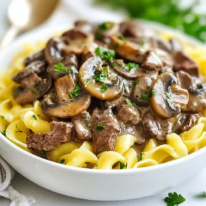 To make a tasty Instant Pot Beef Stroganoff, you need these main ingredients: - 1 pound beef sirloin, thinly sliced - 1 tablespoon olive oil - 1 medium onion, finely chopped - 2 cloves garlic, minced - 8 ounces mushrooms, sliced (cremini or button are best) - 3 cups low-sodium beef broth - 1 teaspoon Worcestershire sauce - 1 tablespoon Dijon mustard - 1 teaspoon dried thyme - Salt and freshly ground black pepper to taste - 1 cup sour cream, at room temperature - 3 tablespoons cornstarch mixed with 3 tablespoons cold water (for thickening) - 12 ounces uncooked egg noodles - Fresh parsley, finely chopped (for garnish) While serving your beef stroganoff, you can add some optional garnishes for extra flair: - A sprinkle of fresh parsley - A dollop of sour cream - Freshly cracked black pepper Using quality ingredients makes a big difference in flavor. Here are some tips: - Choose fresh beef sirloin for the best taste. - Use low-sodium beef broth to control salt levels. - Fresh mushrooms add a richer flavor compared to canned. - Opt for real Dijon mustard, as it enhances the dish's depth. - Ensure your sour cream is at room temperature for a smooth sauce. When you focus on ingredient quality, your Instant Pot Beef Stroganoff will shine. Enjoy the process and the flavors! {{ingredient_image_2}} Start by setting your Instant Pot to Sauté mode. Wait a bit for it to heat up. Add 1 tablespoon of olive oil to the pot. Swirl the oil to coat the bottom well. This helps to prevent sticking and gives flavor. Next, add 1 pound of thinly sliced beef sirloin. Do this in batches to avoid crowding. Sear the beef for about 2-3 minutes on each side. You want it to turn a nice brown color. Once done, take the beef out and place it on a plate. This step adds a lot of flavor to your dish. Now, it’s time for the aromatics. In the same pot, add 1 medium chopped onion and 2 minced garlic cloves. Sauté for about 2-3 minutes. You want the onion to become soft and clear. Then, add 8 ounces of sliced mushrooms. Cook these for another 3-4 minutes until they release their juices and soften up. After the veggies are done, pour in 3 cups of low-sodium beef broth. Add 1 teaspoon of Worcestershire sauce, 1 tablespoon of Dijon mustard, and 1 teaspoon of dried thyme. Make sure to season with salt and pepper to taste. Stir it all together. Put the browned beef back into the pot. Close the lid tightly. Set the pressure valve to sealing. Select Manual mode and cook on high pressure for 10 minutes. Once the time is up, do a quick release of the pressure. Turn the valve to venting carefully to avoid steam burns. After the pressure is gone, open the lid. Stir in 1 cup of sour cream and the cornstarch mixture (3 tablespoons cornstarch mixed with 3 tablespoons cold water). Switch back to Sauté mode. Cook for 2-3 minutes, stirring until the sauce thickens to your liking. Meanwhile, cook 12 ounces of egg noodles in a separate pot according to package instructions. Drain the noodles when they’re ready. To serve, place the cooked egg noodles on plates. Ladle the beef stroganoff sauce over the noodles. For a lovely touch, sprinkle some fresh chopped parsley on top. This makes the dish look nice and adds flavor. Enjoy your comforting meal! To make the best beef stroganoff, follow these simple tips: - Use beef sirloin for a tender bite. - Slice the beef thinly for quick cooking. - Sear the beef well to lock in flavors. - Don't skip the Worcestershire sauce; it adds depth. - Let the sour cream reach room temperature for smooth mixing. Watch out for these common pitfalls: - Overcooking the beef can make it tough. - Adding sour cream too early can curdle it. - Forgetting to season the dish can lead to blandness. - Not stirring the cornstarch mixture well can cause lumps. Try these tips to elevate your stroganoff: - Add a splash of white wine for extra richness. - Mix in some fresh herbs like thyme or parsley for freshness. - Swap in different mushrooms for varied taste, like shiitake. - Top with crispy onions for added crunch. Pro Tips Choose the Right Cut: Opt for tender cuts like sirloin or tenderloin for a more succulent stroganoff that cooks quickly and remains juicy. Don’t Skip the Searing: Browning the beef enhances the flavor of the dish, creating a rich and delicious base for your stroganoff. Adjust the Creaminess: For a lighter version, you can substitute sour cream with Greek yogurt, which provides a similar tang without the extra calories. Fresh Herbs Matter: Adding fresh parsley or thyme as a garnish brightens the dish and adds a fresh flavor that complements the richness of the stroganoff. {{image_4}} You can switch out the beef for other meats if you prefer. Chicken breast works well and cooks quickly. Pork tenderloin is another great choice, adding a nice twist. For a different flavor, try turkey or lamb. Each protein will give the dish a unique taste while keeping it hearty. To make this dish gluten-free, use gluten-free pasta instead of egg noodles. You can also replace the cornstarch with a gluten-free thickener like arrowroot. Check your beef broth for gluten-free labels, as some brands may add wheat. These small changes allow everyone to enjoy this comfort dish. For a vegetarian take, use mushrooms and hearty vegetables like zucchini or bell peppers as the main ingredients. Replace the beef broth with vegetable broth for flavor. If you're vegan, swap sour cream for cashew cream or coconut yogurt. You can also use plant-based proteins like tofu or tempeh, making it delicious and filling. After enjoying your beef stroganoff, let it cool. Place it in an airtight container. You can store it in the fridge for up to three days. Make sure to cover it well to keep it fresh. To reheat, you have a couple of options. You can use the microwave or the stove. If using the microwave, warm it in short bursts. Stir it every minute to heat evenly. On the stove, add a splash of beef broth and heat on low. Stir until warm. You can also freeze beef stroganoff for later. Place it in a freezer-safe container. Leave some space at the top as it will expand. It can last up to three months in the freezer. To eat, thaw it in the fridge overnight, then reheat. The best way to thicken Beef Stroganoff is by using cornstarch mixed with water. After cooking, stir in the cornstarch mixture. Cook it on sauté mode for a few minutes. This method gives a nice, creamy texture. You can also use sour cream for added richness. Yes, you can use fresh mushrooms instead of canned. Fresh mushrooms add great flavor and texture. I recommend using cremini or button mushrooms. They both work well in this dish. Just slice them and add them to the pot when sautéing. You know the beef is perfectly cooked when it is tender and no longer pink. After pressure cooking for 10 minutes, the beef should be soft. If you want to check, cut a piece in half. It should be easy to cut and juicy inside. You can serve this dish with egg noodles, rice, or mashed potatoes. The sauce pairs well with many sides. For a fresh touch, add a side salad or steamed veggies. Fresh bread also works well to soak up the sauce. Yes, you can make this recipe without an Instant Pot. You can use a large pot or skillet instead. Just sauté the ingredients as directed, then simmer on low heat until the beef is tender. This may take longer but will still taste great. In this article, I covered how to make Instant Pot Beef Stroganoff, including key ingredients and steps. We discussed tips for perfecting your dish, variations for different diets, and storage methods for leftovers. Finally, I answered common questions to help you succeed. Enjoy making this savory meal—it’s easy and fun! With practice, you’ll impress everyone at the table with your cooking skills.
