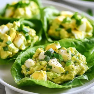 - 4 hard-boiled eggs, peeled and coarsely chopped - 1 ripe avocado, perfectly mashed - 2 tablespoons Greek yogurt (or creamy mayonnaise) - 1 tablespoon Dijon mustard - 1 tablespoon freshly squeezed lemon juice - 1 green onion, finely chopped - Sea salt and freshly cracked black pepper to taste - 8 large lettuce leaves (Romaine or Butter) - Optional: Fresh herbs like cilantro or parsley, finely chopped You can swap Greek yogurt for creamy mayonnaise for a different taste. If you want a kick, try spicy mustard instead of Dijon. For a vegan option, use mashed chickpeas or silken tofu instead of eggs. You can also replace lettuce with collard greens or cabbage for a sturdy wrap. Avocados are rich in healthy fats and fiber. They support heart health and help keep you full. Eggs provide high-quality protein, which is good for muscle health. Greek yogurt adds probiotics, promoting gut health. Green onions add vitamins A and C, boosting your immune system. Lettuce is low in calories and high in water, making it great for hydration. {{ingredient_image_2}} Start by gathering all your ingredients. You need four hard-boiled eggs, one ripe avocado, and some Greek yogurt or mayonnaise. Add Dijon mustard, lemon juice, and one green onion to your list. Don’t forget sea salt and black pepper for seasoning. Choose large lettuce leaves, like Romaine or Butter lettuce, for the wraps. In a medium bowl, add the coarsely chopped hard-boiled eggs. Then, take your ripe avocado and mash it well before adding it to the bowl. Next, mix in two tablespoons of Greek yogurt or creamy mayonnaise. Add one tablespoon of Dijon mustard and the lemon juice. Stir everything together gently until it’s creamy and smooth. Now, finely chop your green onion and fold it into the mixture. Season with sea salt and freshly cracked black pepper to taste. This will enhance the flavors and make your egg salad delicious. Take one lettuce leaf and place about two to three tablespoons of the egg salad in the center. If you like, sprinkle some chopped fresh herbs on top for extra flavor. Gently fold the lettuce around the filling to create a wrap. Repeat this with the remaining leaves and egg salad until everything is used up. For a nice presentation, arrange the wraps on a platter. You can garnish with more fresh herbs for a pop of color. Enjoy your fresh and tasty avocado egg salad lettuce wraps! To boil eggs well, start with cold water. Place your eggs in a pot and add enough water to cover them. Bring the water to a gentle boil. Once boiling, turn off the heat and cover the pot. Let the eggs sit for about 9-12 minutes depending on how cooked you like them. After that, transfer the eggs to an ice bath. This will stop cooking and make peeling easier. For a creamy texture, mash the avocado well. Mix it with Greek yogurt or creamy mayonnaise. Adding Dijon mustard gives a nice tang. Fresh lemon juice brightens the flavor, while green onions add crunch. Season with sea salt and black pepper to taste. For extra flavor, add finely chopped herbs like cilantro or parsley. Serve the avocado egg salad in fresh lettuce wraps. Romaine or Butter lettuce works best for this. You can arrange the wraps on a platter for a pretty look. For an extra touch, garnish with more herbs. Pair these wraps with a light soup or fresh fruit salad for a complete meal. Enjoy your fresh and tasty creation! Pro Tips Choose the Right Lettuce: Opt for Romaine or Butter lettuce for the best wraps, as they provide a sturdy structure and a fresh flavor that complements the egg salad. Perfectly Mash Avocado: Ensure your avocado is ripe for easy mashing. A perfectly mashed avocado enhances the creaminess of the egg salad. Season to Taste: Don't hesitate to adjust the seasoning with sea salt and black pepper. Taste as you go to achieve the perfect flavor balance. Add Your Twist: Feel free to mix in your favorite ingredients, such as diced tomatoes or cucumbers, for a personalized touch that adds flavor and texture. {{image_4}} You can switch up the dressing to suit your taste. Instead of Greek yogurt, try sour cream or avocado oil for a different flavor. You can add a touch of hot sauce if you like heat. Pickles or capers can also bring a nice zing to the salad. Feel free to mix in diced celery or bell peppers for a crunchy twist. To make a vegan version, replace eggs with mashed chickpeas or tofu. Use a vegan mayo or tahini instead of Greek yogurt. For a low-carb option, skip the yogurt and keep the avocado. Use diced cucumbers instead of lettuce wraps for a fresh crunch. This keeps the dish light and healthy while still being delicious. Garnishing adds flair to your wraps. Fresh herbs like cilantro or parsley brighten up the dish. You can also sprinkle some paprika or chili flakes for extra color. Chopped nuts, like walnuts or almonds, add crunch and flavor. For a fun touch, add edible flowers to your platter for a beautiful presentation. To store leftover egg salad, place it in an airtight container. This keeps it fresh longer. Make sure to press plastic wrap onto the salad before sealing. If you skip this step, air can dry it out. Leftover egg salad lasts for three days in the fridge. If it turns brown, it's best to toss it. Lettuce wraps are best when fresh. If you need to store them, keep the filling and leaves separate. Wrap the filling in plastic wrap and place it in a container. Store the lettuce leaves in a damp paper towel. This helps them stay crisp. When ready to eat, fill the lettuce with the salad. Egg salad does not freeze well. It can change in texture and flavor. However, if you want to save it, use the fridge. After three days, it’s time to let it go. If you have extra lettuce, it can last a week. Just remember, the fresher the better! Enjoy your wraps while they are still crisp and tasty. Yes, you can use avocado instead of mayonnaise. Avocado adds creaminess and flavor. It also boosts nutrition. Avocado has healthy fats and fiber. This swap makes the dish lighter and fresher. Romaine and Butter lettuce are the best for wraps. Romaine has a crisp texture and strong shape. Butter lettuce is soft and tender, making it easy to fold. Both types hold the filling well. Avocado egg salad lasts about 1-2 days in the fridge. To keep it fresh, store it in an airtight container. Check for color changes or off smells before eating. Use fresh ingredients for the best taste. Yes, you can make this recipe ahead of time. Prepare the egg salad and store it in the fridge. Just wait to assemble the wraps until you are ready to eat. This keeps the lettuce crisp and fresh. This blog post covers making a tasty egg salad in lettuce wraps. We started with the key ingredients and their health benefits. I shared tips to boil eggs and make the salad creamy. We explored variations for different diets and how to store leftovers. In the end, this dish is fun and easy. Feel free to get creative with flavors and toppings. Enjoy your egg salad wraps—healthy meals can be simple and delicious!